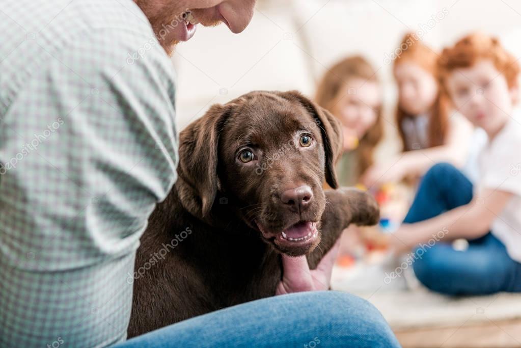 father holding puppy