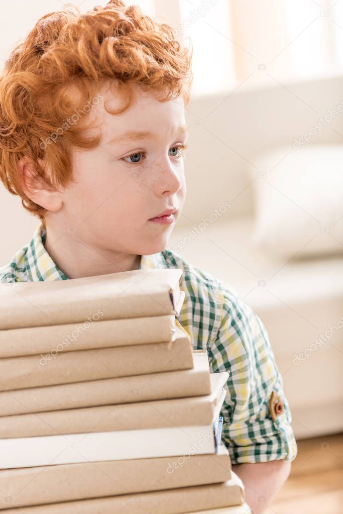 little boy and pile of books