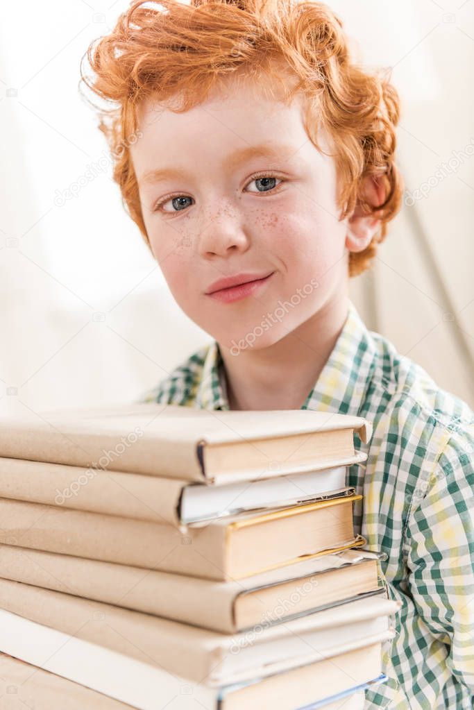 little boy and pile of books