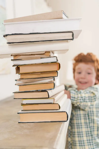 Kleine jongen en stapel boeken — Stockfoto