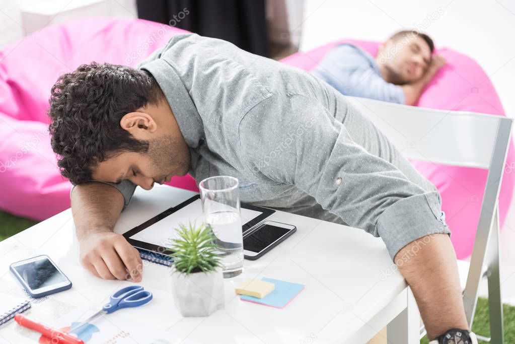 Businessmen sleeping at modern office