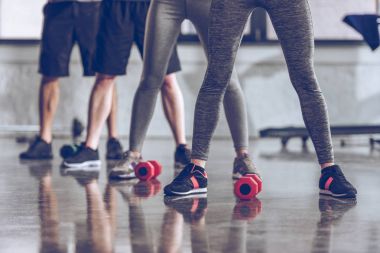 Sporty people exercising in gym  clipart