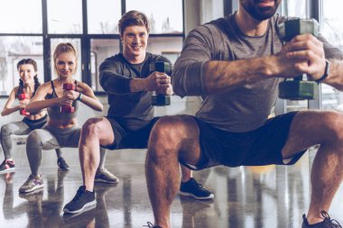 Sporty people exercising in gym  clipart