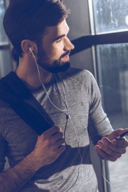 man listening music in earphones clipart
