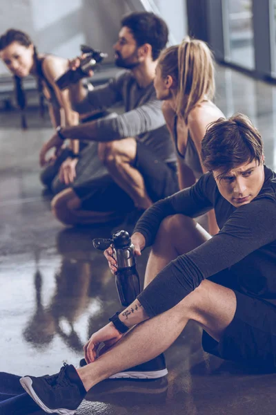 Gente deportiva descansando en el gimnasio — Foto de Stock