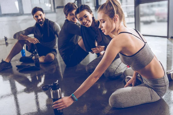 Gente deportiva descansando en el gimnasio — Foto de Stock