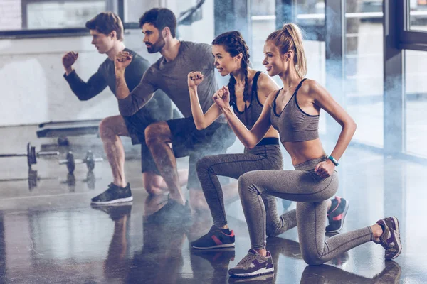 Sportiga människor träna i gym — Stockfoto