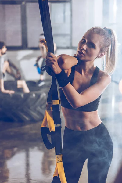 Sportive woman with trx equipment — Stock Photo, Image
