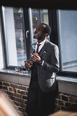 Kendine güvenen işadamı viski ve sigara puro ile cam holding
