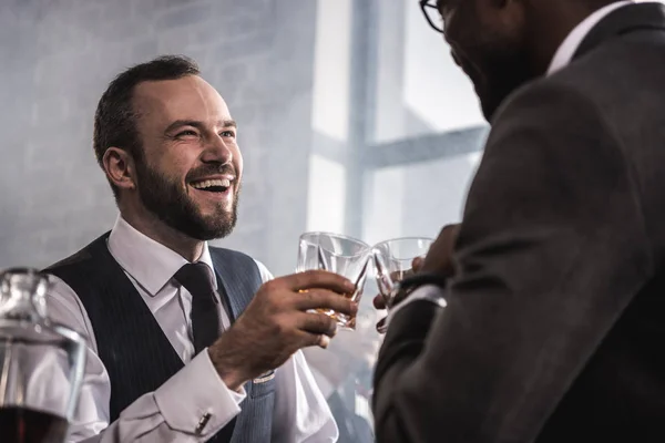 Dois homens de negócios em uso formal vestindo copos de uísque e conversando — Fotografia de Stock