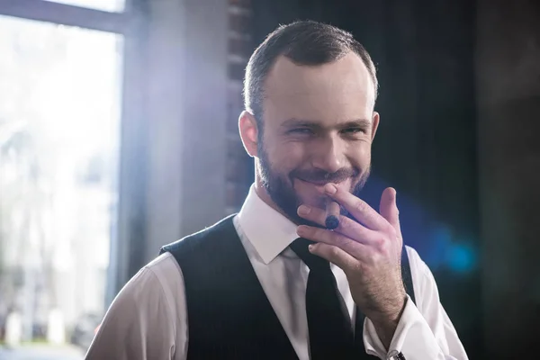 Szczegół portret przystojny uśmiechający się pewny siebie człowiek palenia cygar pomieszczeniu — Zdjęcie stockowe