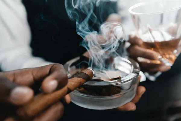 Multikulti-Business-Team verbringt Zeit, raucht Zigarre und trinkt Whiskey — Stockfoto