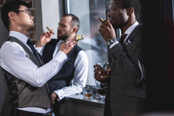 group of businessmen smoking cigars together during break