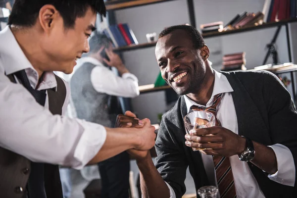 Веселі колеги п'ють алкоголь, проводячи час разом після роботи — стокове фото
