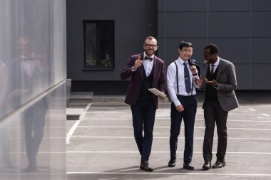 gülümseyen çok kültürlü iş modern ofis binası yakınında sokakta yürüme