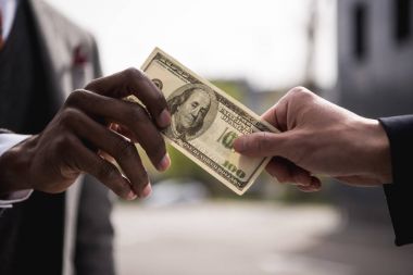anonymous businessmen hands holding one hundred dollars banknote outdoors clipart