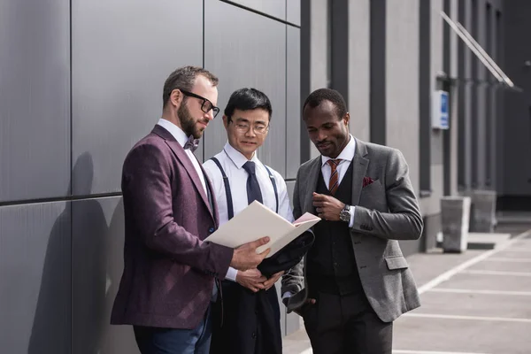 Multicultural business team discussing work together near modern office building — Stock Photo, Image