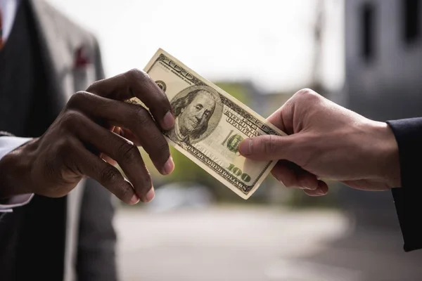 Anonymous businessmen hands holding one hundred dollars banknote outdoors — Stock Photo, Image
