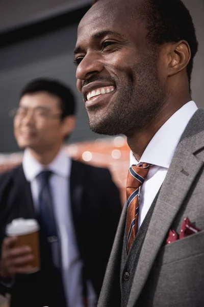 Jóvenes sonrientes hombres de negocios multiétnicos que se reúnen en el coffee break al aire libre, reunión de equipo de negocios — Foto de Stock