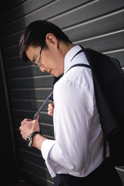 Jonge stijlvolle Aziatische zakenman in glazen permanent buitenshuis — Gratis stockfoto