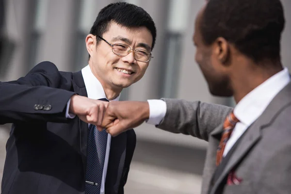 Young smiling multiethnic businessmen in formalwear celebrating success, business team meeting — Stock Photo, Image