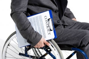 businessman in wheelchair holding clipboard with contract