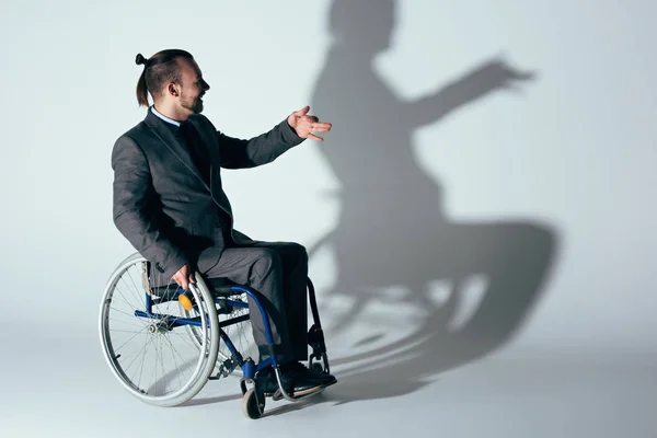 Hombre de negocios en silla de ruedas haciendo sombra de perro — Foto de Stock