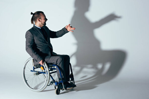 businessman in wheelchair making shadow of dog