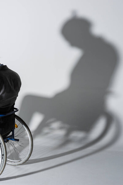 physically handicapped man in wheelchair with shadow