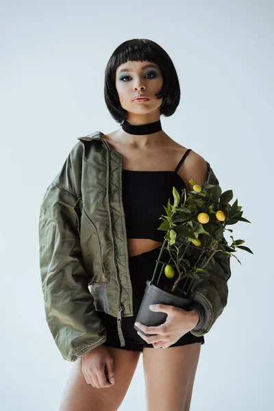 Menina com cabelo e planta bobbed — Fotografia de Stock