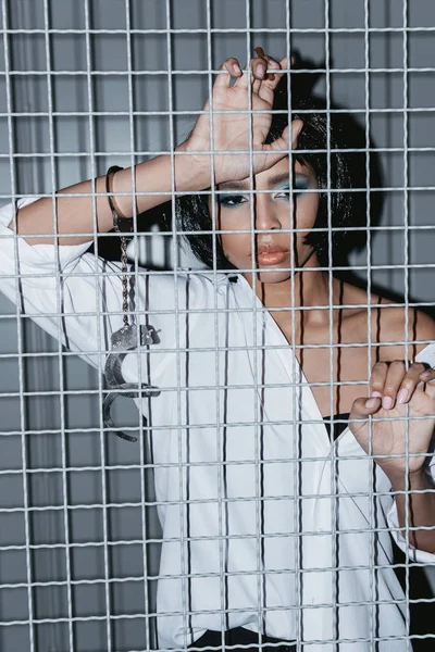 Woman in shirt behind grate — Stock Photo, Image