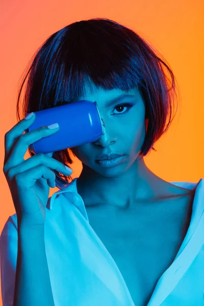 Woman holding can in front of face — Stock Photo, Image