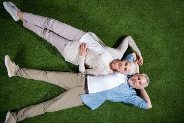 Senior couple lying on grass  clipart