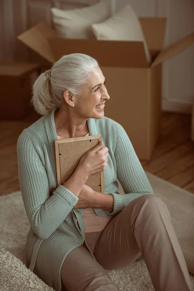 Senior woman hugging photo in frame — Stock Photo, Image