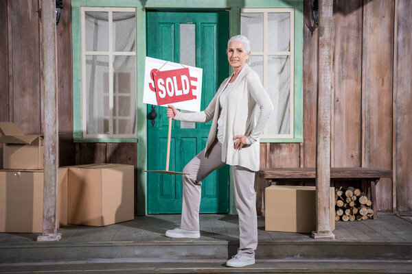 Senior woman near sold house 