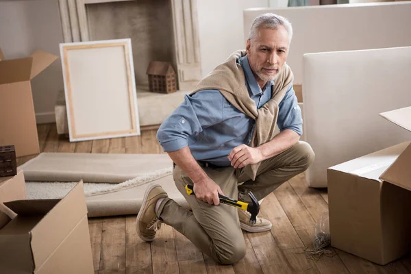 Senior man with hammer in hand — Stock Photo, Image