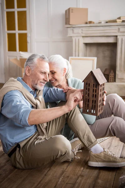 Casal olhando para o modelo da casa — Fotografia de Stock