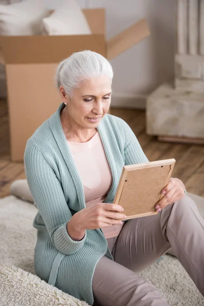 Mujer sosteniendo marco de foto — Foto de Stock