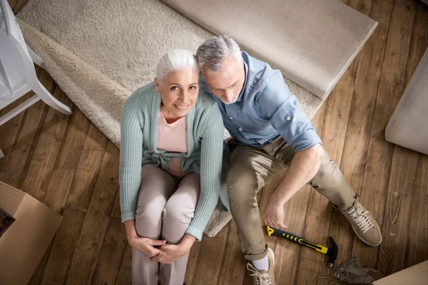 Senior couple embracing while sitting at home — Stock Photo, Image