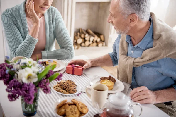 Man presenting gift to wife during breakfast — Stock Photo, Image