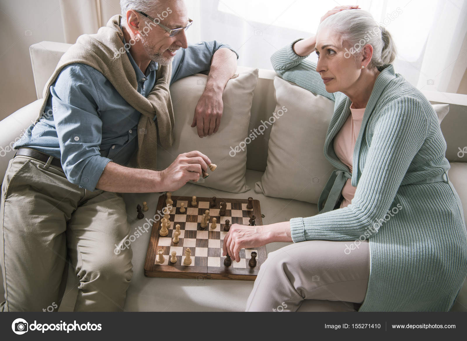 Старший пара говорить во время игры в шахматы — Стоковое фото