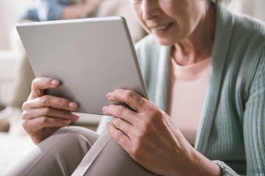 Dijital tablet kullanan yaşlı kadın