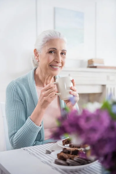 Grey haired woman drinking coffee — Stock Photo, Image