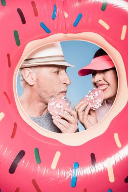 elderly couple eating sweet doughnuts clipart