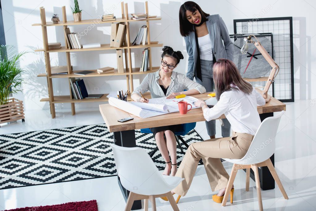 Businesswomen working with blueprints 