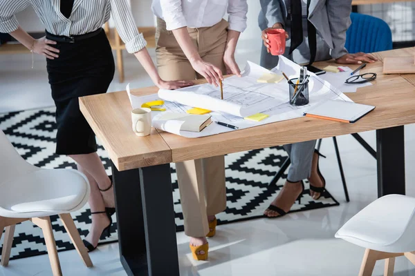 Arquitectos trabajando con planos en la mesa — Foto de Stock