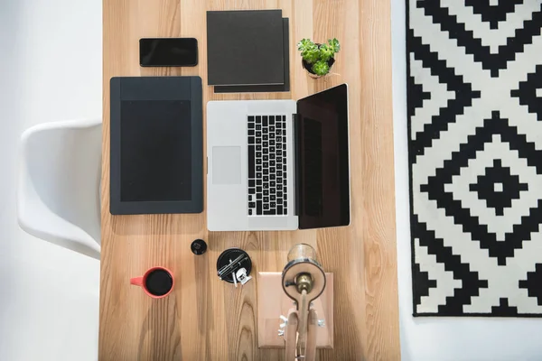 Portátil con gráficos tableta y smartphone en la mesa — Foto de Stock