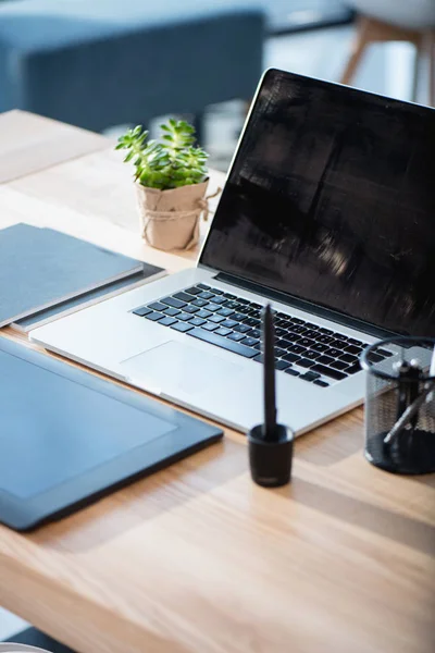 Laptop com tablet gráfico em mesa de madeira — Fotografia de Stock