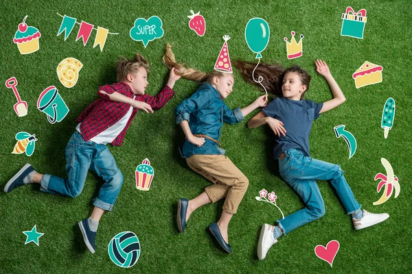 Feliz três amigos deitados na grama — Fotografia de Stock