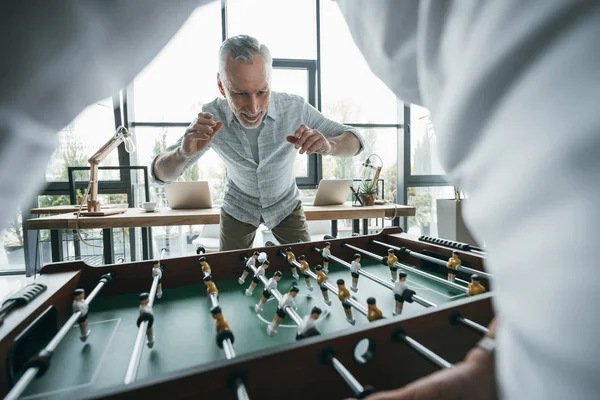 Colleagues playing foosball — Free Stock Photo